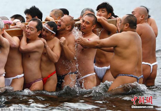 当地时间1月17日，日本藤泽市举行冬日成人祭典活动，众人赤裸身体抬着浮动神龛冲入海中。这项年度活动一是为了庆祝年轻人的成年礼，二是为了祈祷平安健康。