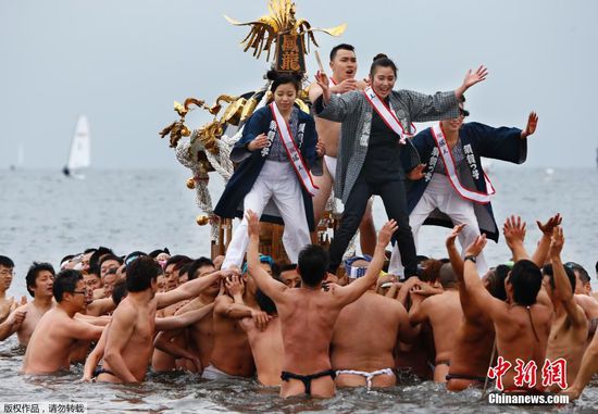 当地时间1月17日，日本藤泽市举行冬日成人祭典活动，众人赤裸身体抬着浮动神龛冲入海中。这项年度活动一是为了庆祝年轻人的成年礼，二是为了祈祷平安健康。