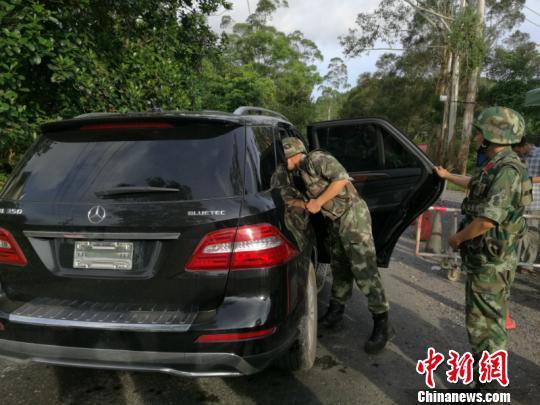 图为边防警察对可疑车辆进行检查 林浩 摄