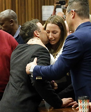 Oscar Pistorius kisses his sister Aimee after his sentence is read out in the High Court in Pretoria. (AFP)