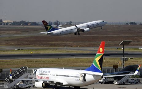 A South African airways flight takes off as another one is parked in a bay on the tarmac on 25 May, 2010 at the Johannesburg O.R Tambo International airport in Johannesburg, South Africa. Picture: AFP