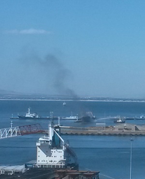 The harbour tug Palmiet sprays water on the side of the fishing trawler Verano in the Cape Town harbour. (Hanlie Gouws, News24)