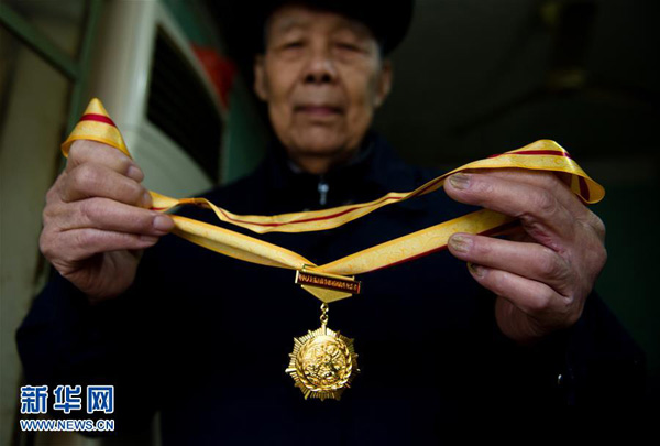 李高山展示自己的抗战胜利70周年纪念章（11月21日摄）。