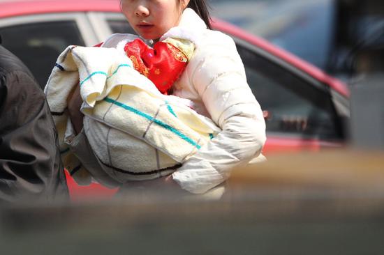 　　▲2月15日，长沙今日最高温度达20℃。在湖南省儿童医院，即使天气很热，小孩仍被包裹得严严实实。图|记者金林