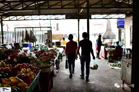 向杰和阿笋在老挝的农贸市场给阿笋父母买水果。
