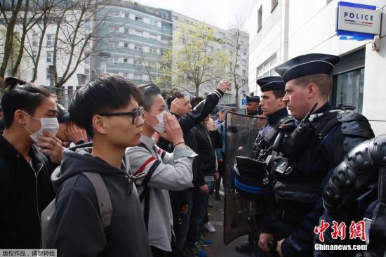 当地时间28日，在法国巴黎的亚裔民众在巴黎警察局门外与法国防暴警察对持。