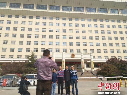 外地游客在雄县政府大楼前拍照留念 王天译 摄