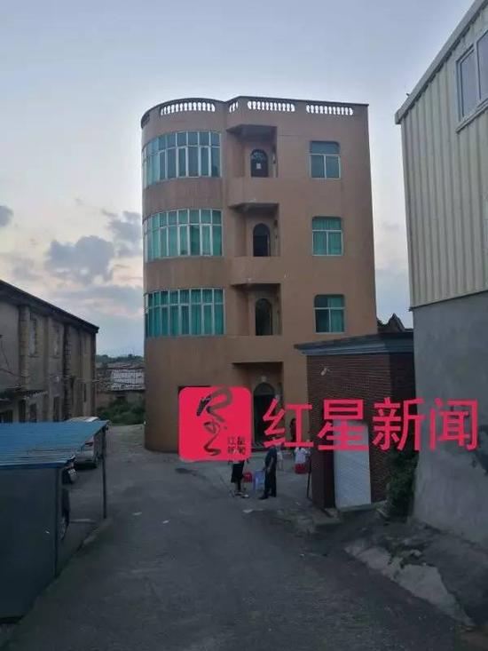▲村民告诉记者，这栋四层楼的建筑就是两姐妹的家。