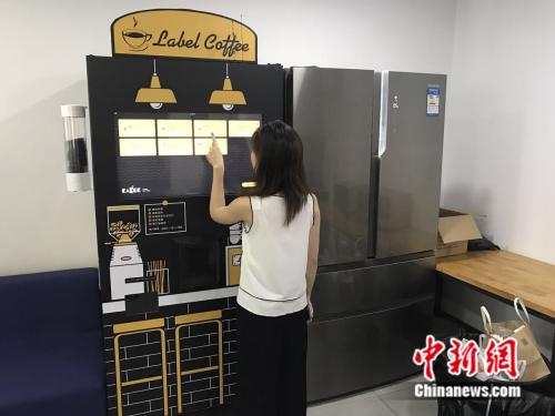 2017年7月21日，北京三里屯SOHO内，一名白领正在使用自动咖啡售卖机。潘心怡 摄