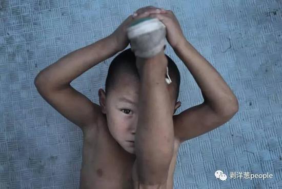 8月1日，河南“濮阳市艺术公益培训基地”。6岁的“二虎”正在练习压腿，他是这里年龄最小的。