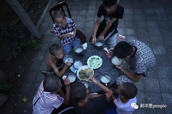 8月1日，孩子们三五成群地在一起吃晚饭。晚饭是韭菜鸡蛋、米粥和馒头。