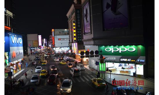 资料图片：2017年2月27日，广东省东莞市塘厦镇手机店铺夜景。（图片来源：视觉中国）