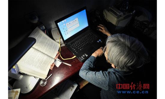 资料图片：2017年5月17日，天津。薛敏修在利用电脑学习。2014年，78岁的薛敏修正式成为天津大学现代远程教育电子商务专业的本科学生。（图片来源：视觉中国）