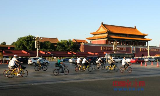 资料图片：2017年9月17日，北京。市民骑共享单车行驶在天安门前及长安街上。（图片来源：视觉中国）