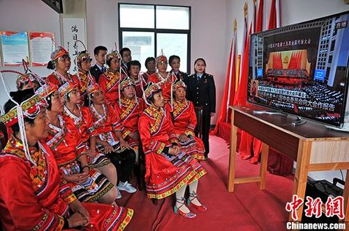 10月18日，在江西省上饶市铅山县篁碧畲族乡畲族村，该村几十位畲族同胞身穿鲜艳的民族服装，齐聚村委会观看十九大开幕式电视直播盛况。 中新社记者 丁铭华 摄