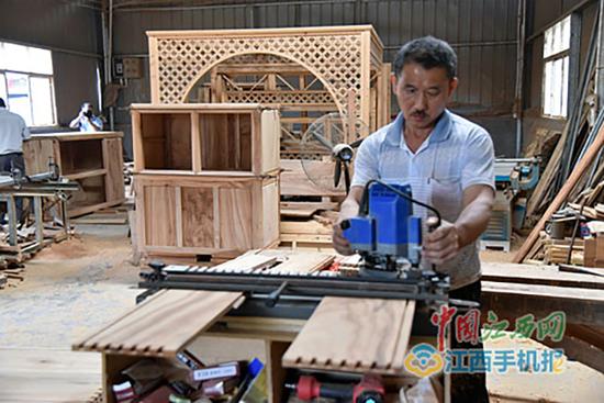 村里办起了十多家仿古家具加工厂。中国江西网 图