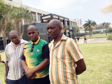 Thembinkosi Maliti, left, and Thandaza Mankayi, right, the fathers of the two 10-year-old murdered boys, are comforted by ANC Ward 33 councillor Sya Njokweni outside the Durban Magistrate’s Court yesterday. Picture: Sne Masuku